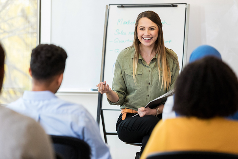 Profesora dando clase frente a un grupo de alumnos